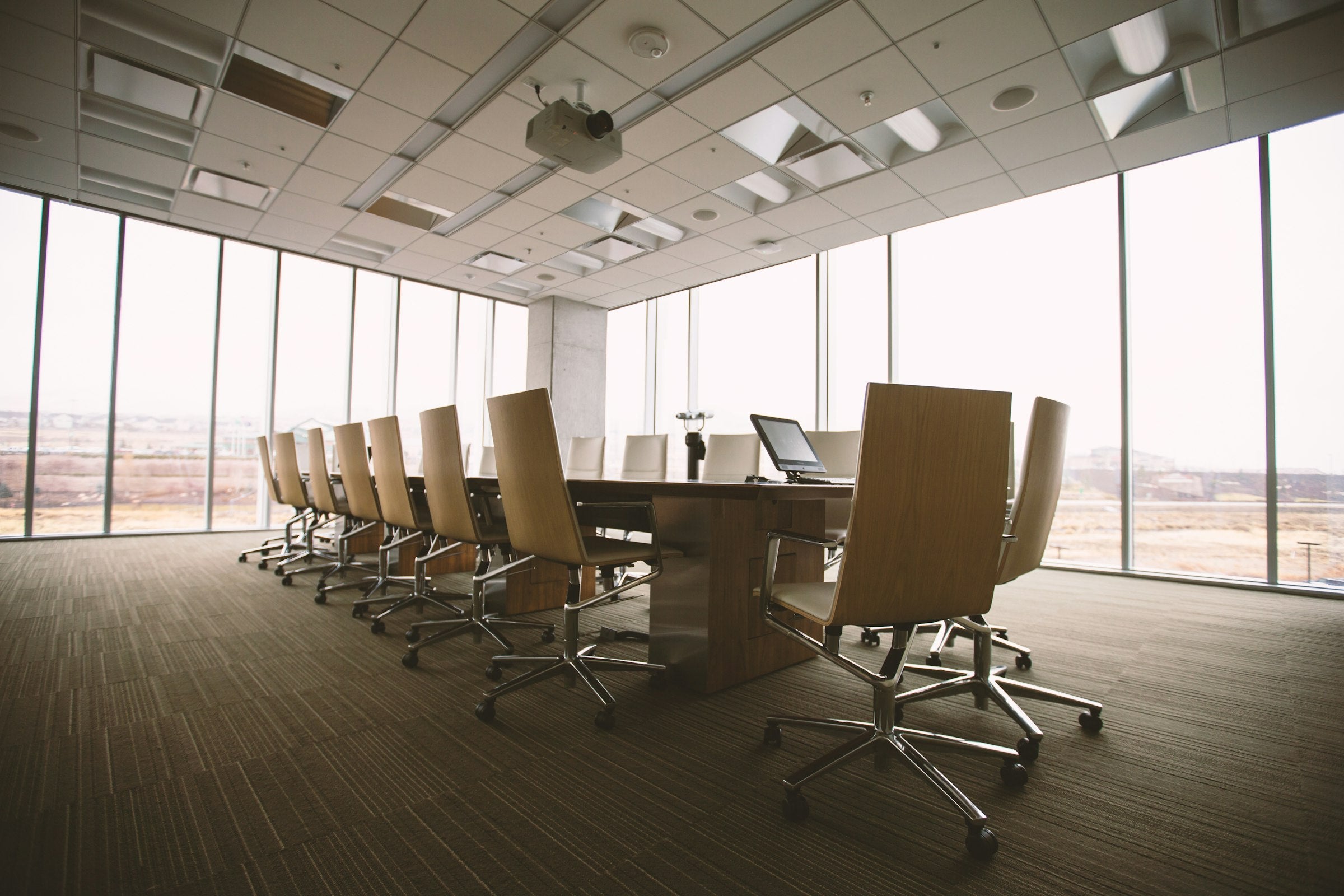 Minimalist boardroom with oval wooden conference table